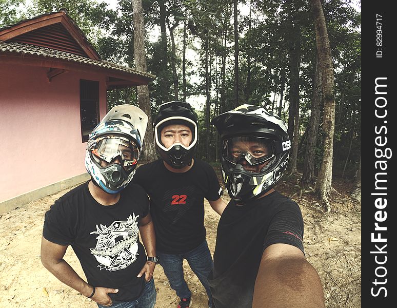 Selfie of group of dirt bikers in helmets outside in woods.