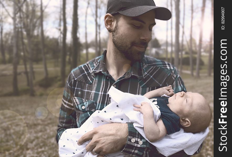 Man Holding Baby during Daytime