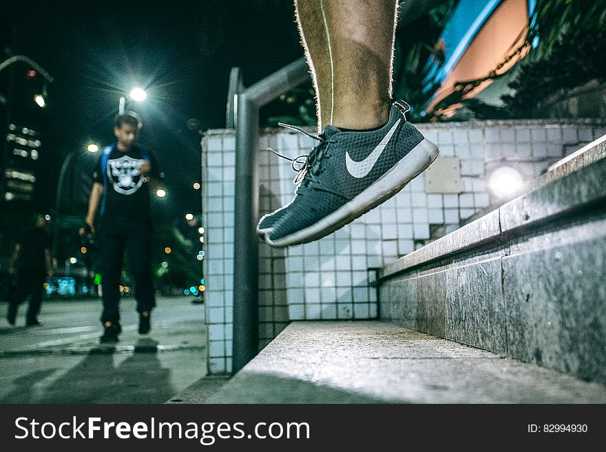 Man in Black White Nike Shoes during Nighttime