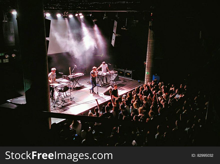 High angle view of band on stage playing concert to audience.