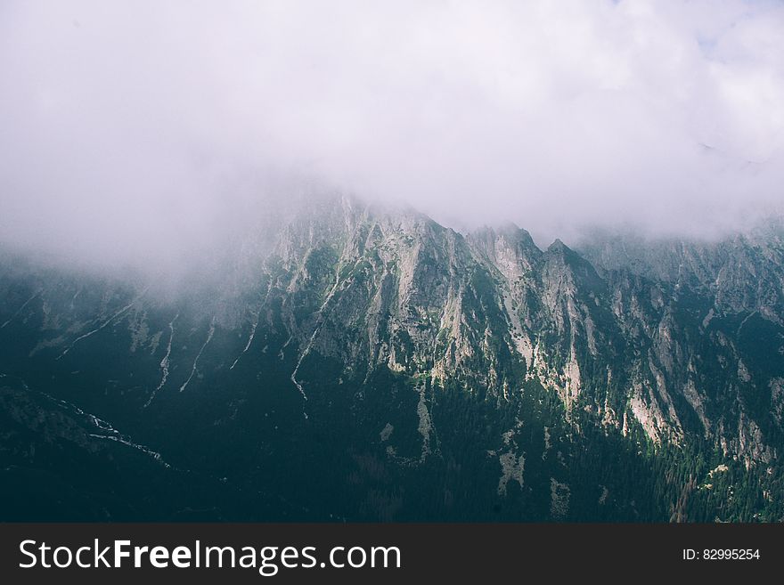 A mountain range with mist or clouds hanging over. A mountain range with mist or clouds hanging over.