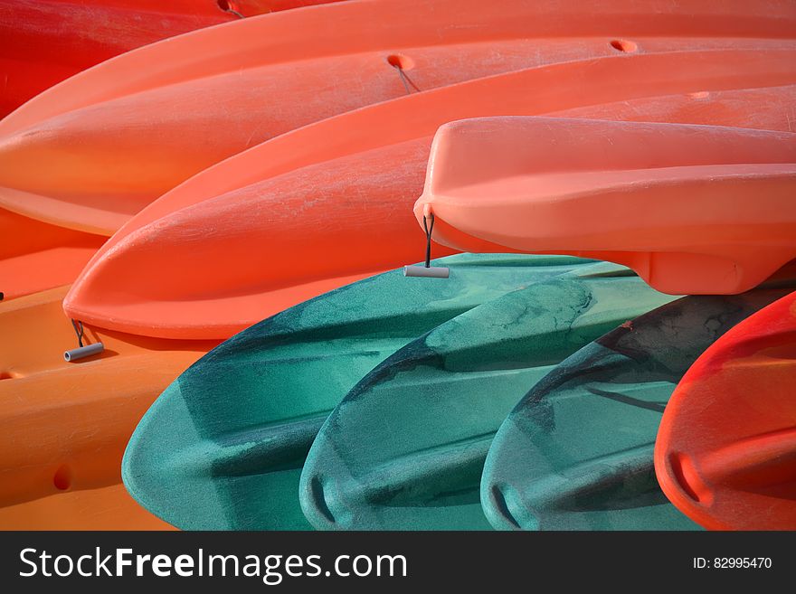 Red and blue plastic canoes stacked outdoors. Red and blue plastic canoes stacked outdoors.
