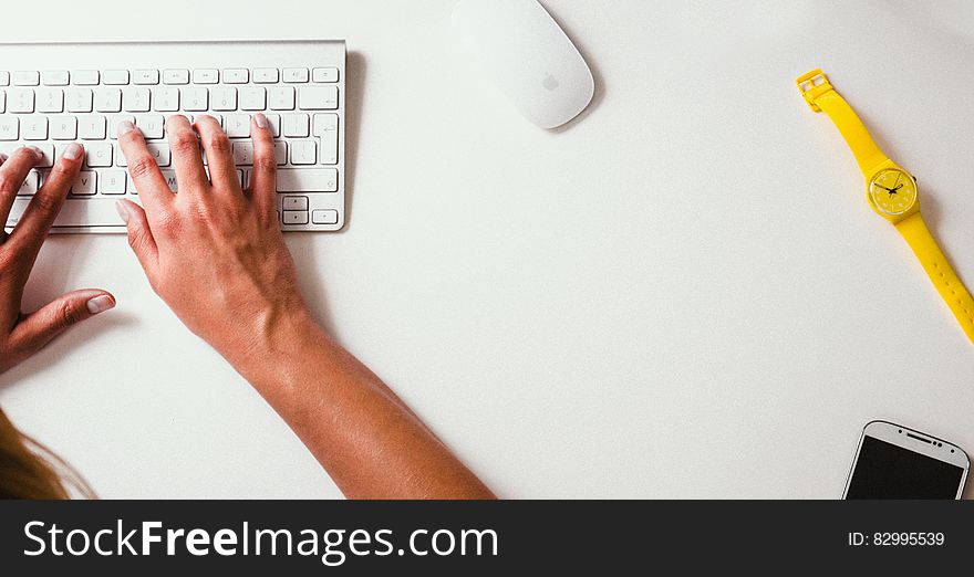 Overhead view of person at desk typing on keyboard with watch and copy space. Overhead view of person at desk typing on keyboard with watch and copy space.