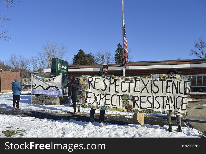 Protesters with sign reading respect existence, expect resistance outside bank building in Standing Rock, North Dakota. Protesters with sign reading respect existence, expect resistance outside bank building in Standing Rock, North Dakota.