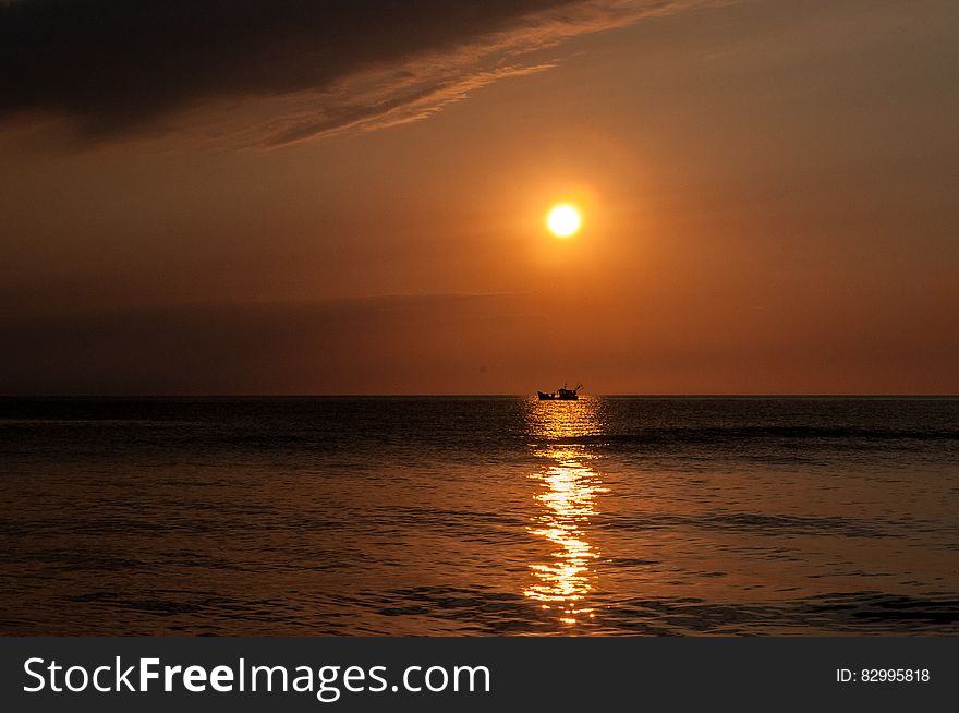 Sunset over boat on water