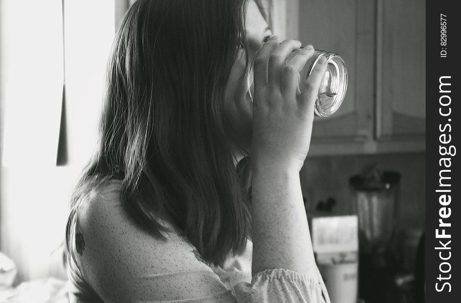 Grayscale Photo of Lady Drinking Water