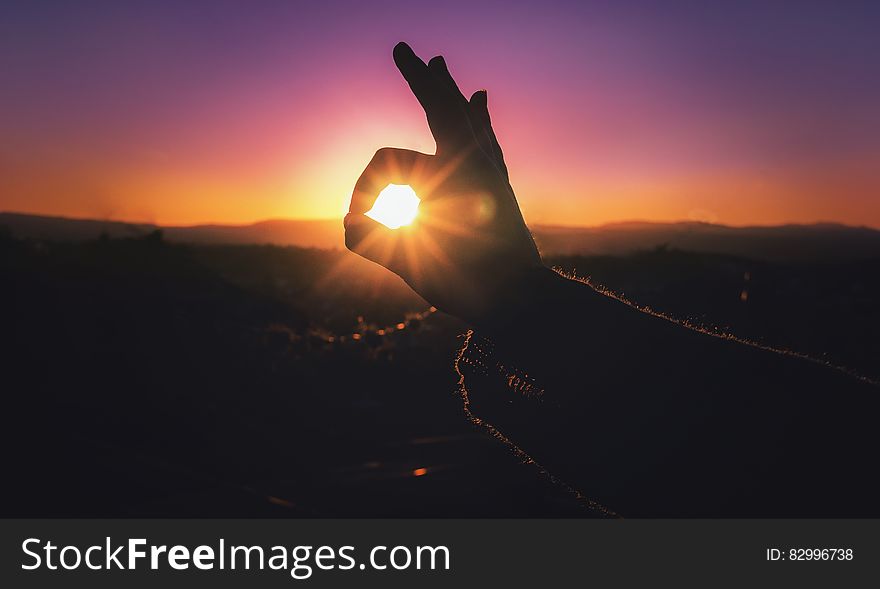Person Doing Ok Hand Sign during Sunset
