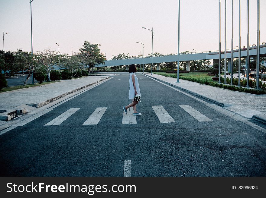 Woman Standing on Gray and White Road Crosswalk