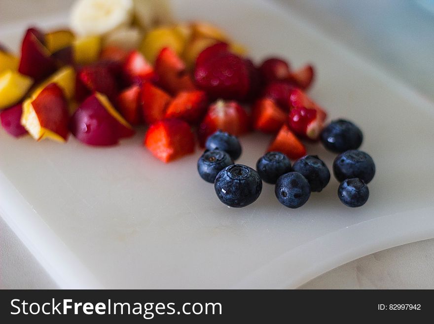 Black Berries With Sliced Fruits on White Plate