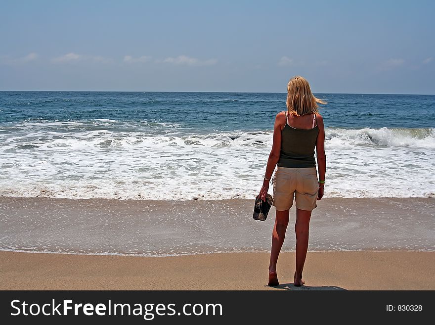 Blond girl, barefoot, staring at the ocean. Blond girl, barefoot, staring at the ocean.