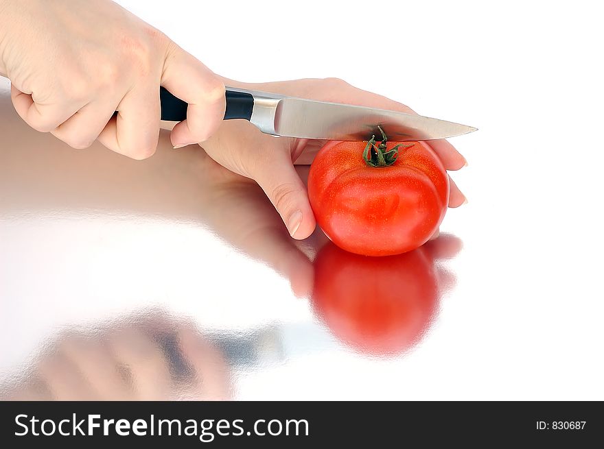 Woman hands cutting a tomato. Woman hands cutting a tomato