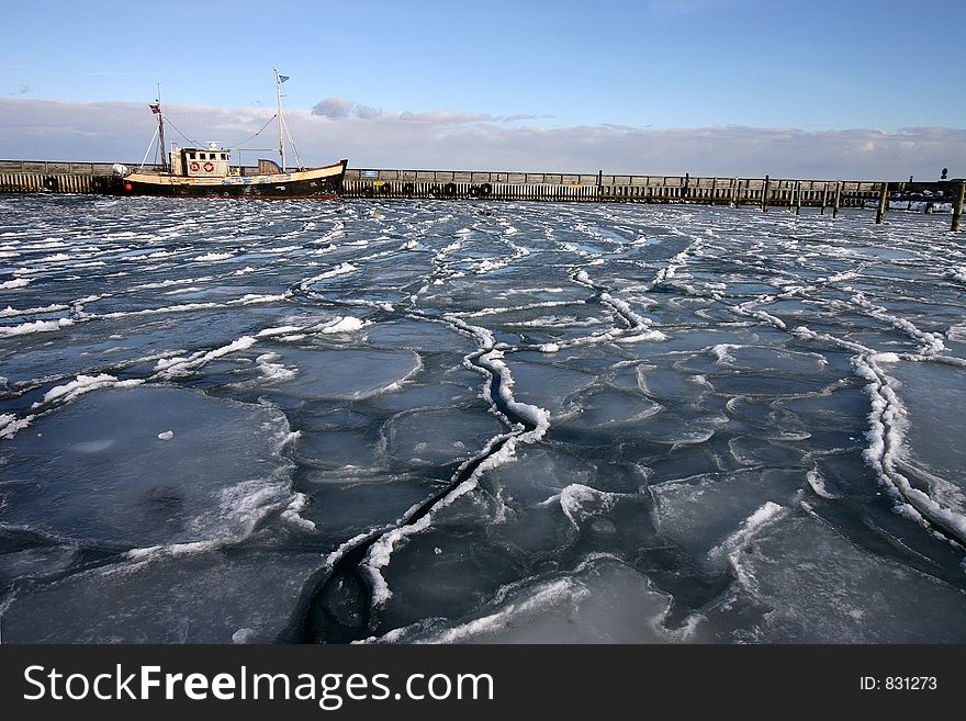 Fishing boat in the ice in a small danish harbour