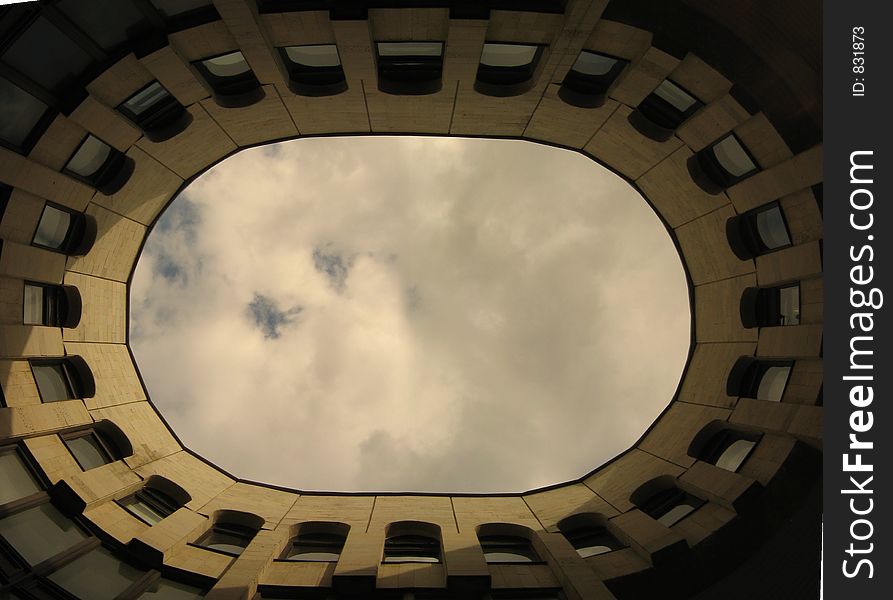 Cloudy sky seen upward from an oval yard. Cloudy sky seen upward from an oval yard