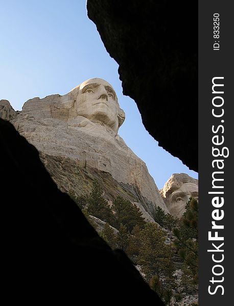 Mt Rushmore as seen looking out from inside a cave, dark areas for text. Mt Rushmore as seen looking out from inside a cave, dark areas for text