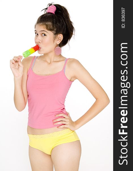 A pretty young asian woman sucking on an ice lolly
