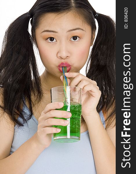 A pretty young asian woman drinking a green drink through a straw
