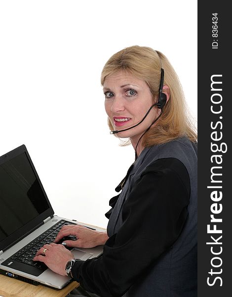 Attractive, smiling, customer service operator representative working at a computer with telephone headset. Attractive, smiling, customer service operator representative working at a computer with telephone headset