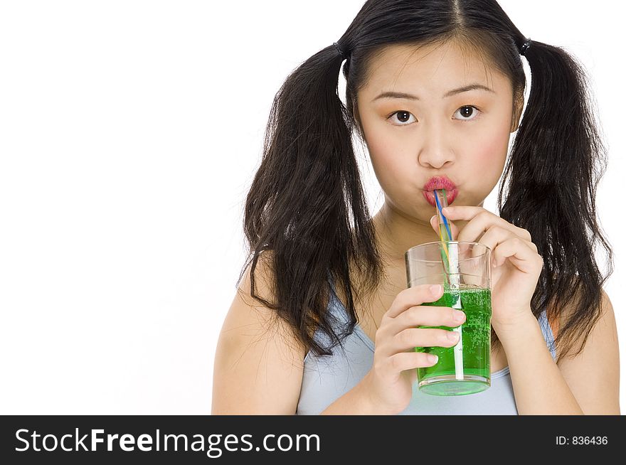 A cute young asian woman drinking a green drink. A cute young asian woman drinking a green drink