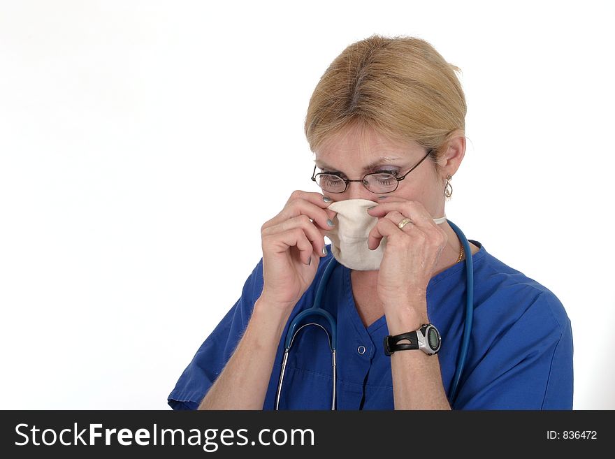 Headshot photo of nurse or doctor with glasses and stethoscope putting on a surgical mask preparing for surgery or an operation or a procedure. Headshot photo of nurse or doctor with glasses and stethoscope putting on a surgical mask preparing for surgery or an operation or a procedure
