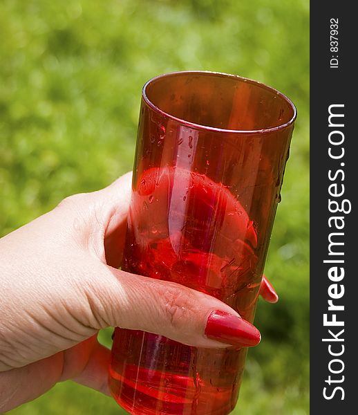 Hand holding a red glass. Hand holding a red glass