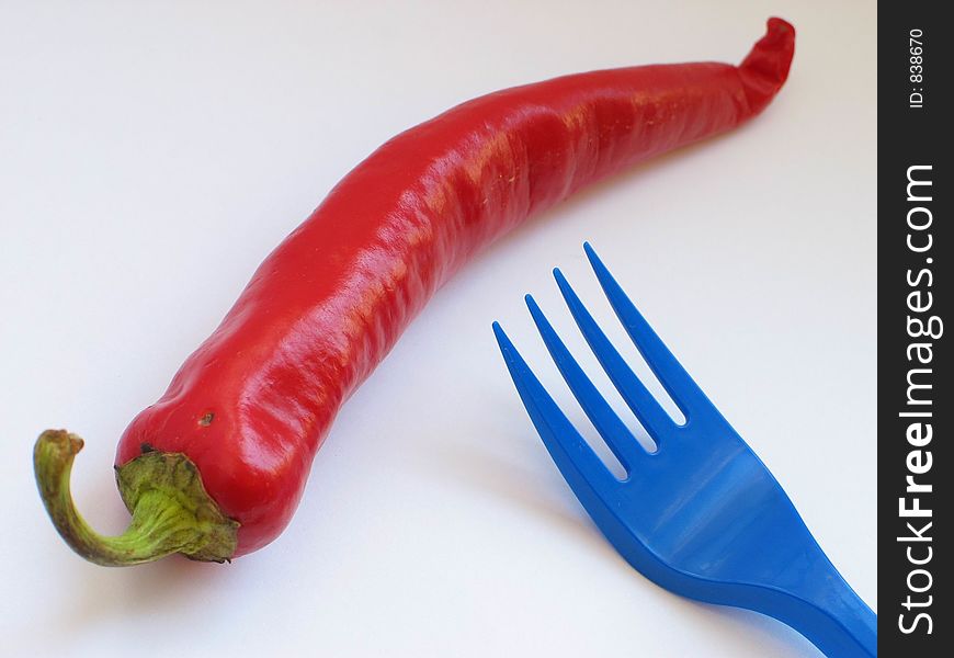 Red pepper and blue fork over white. Red pepper and blue fork over white
