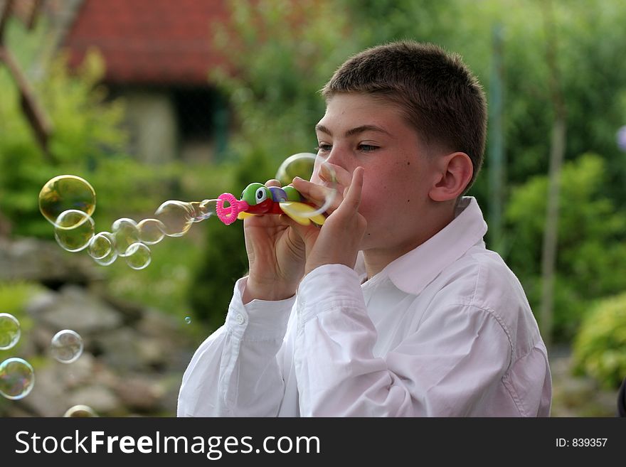Boy blow soap-bubble in the garden . Boy blow soap-bubble in the garden