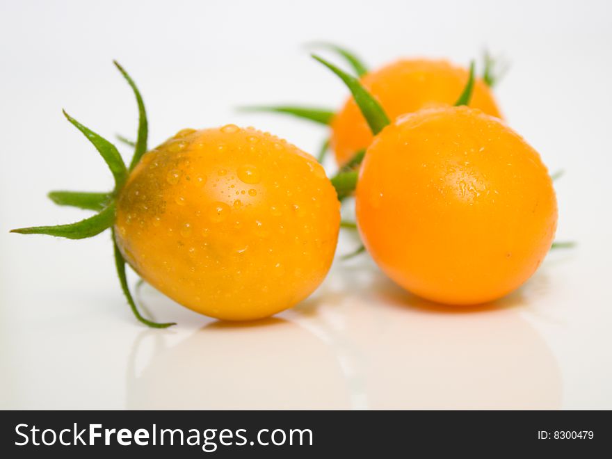 Perfect yellow tomatoes covered water drops. Shallow DOF.