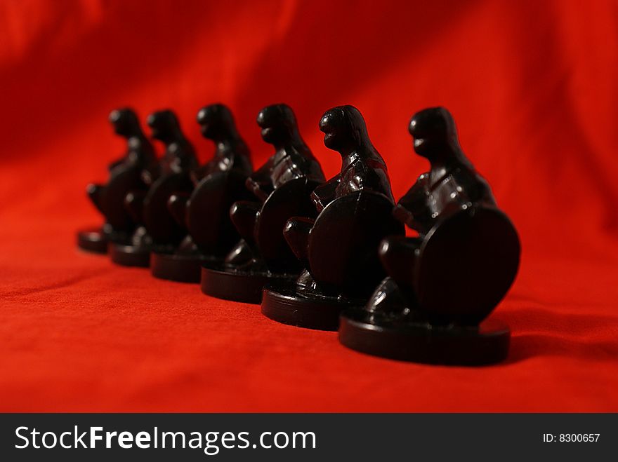 Row of chess figures on red background. Row of chess figures on red background