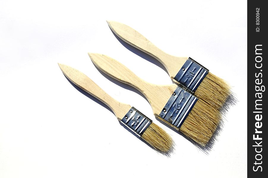 Group of three paint brushes on a white background
