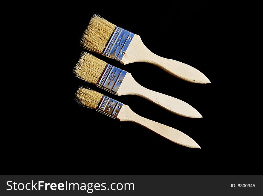 Composition of three paint brushes on black background. Composition of three paint brushes on black background
