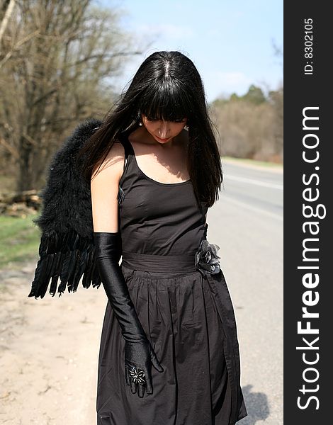 Sad black angel at road. Sad black angel at road