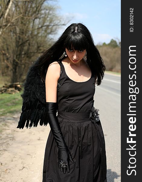 Black angel outdoors in the road