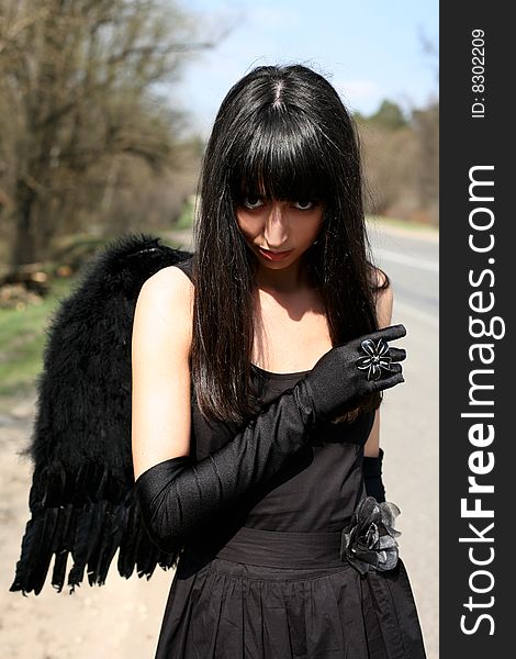 Black angel outdoors at road