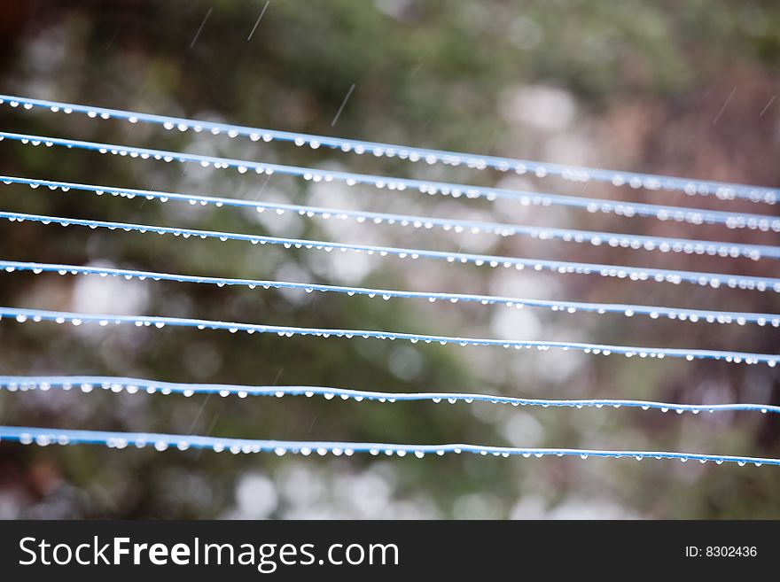 Raindrops on blue stave with falling rain.