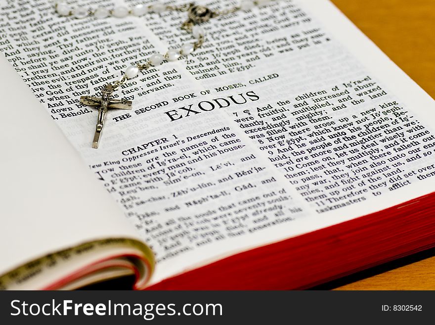 Close up of Exodus bible page with rosary. Close up of Exodus bible page with rosary