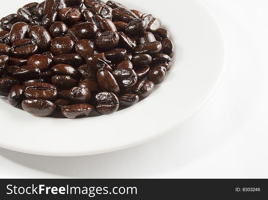 A white plate with coffee beans.
Light from above left; reflection in beans.