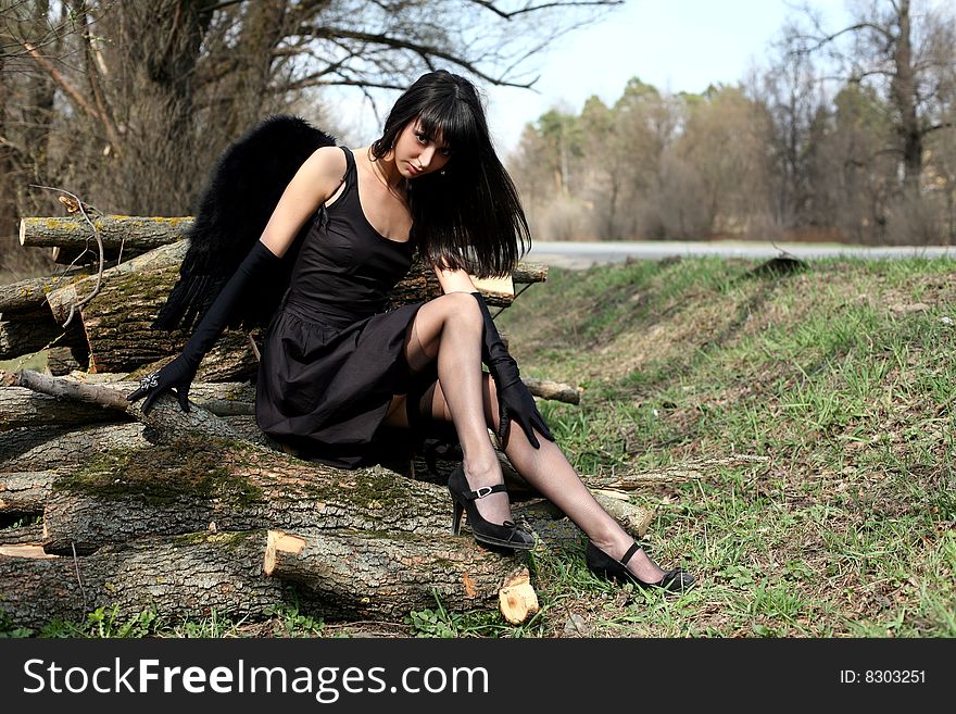 Sitting lovely black angel outdoors