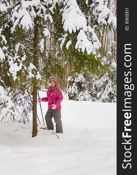 Little girl is having fun under firtree in winter. Little girl is having fun under firtree in winter