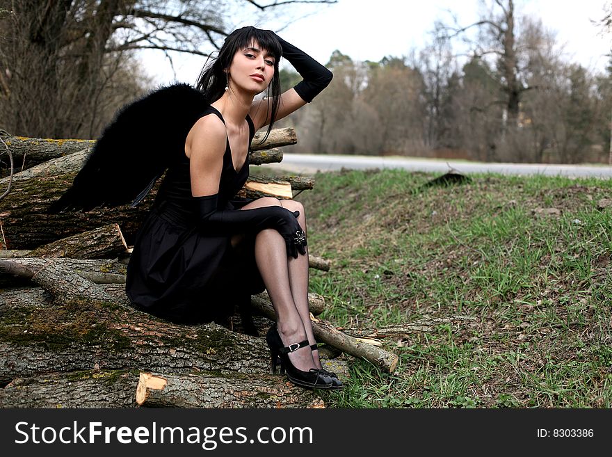 Sitting lovely black angel outdoors