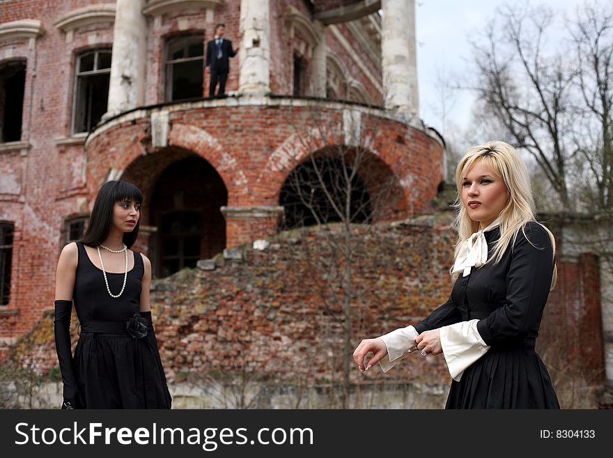 Two girl and man beside old house. Two girl and man beside old house