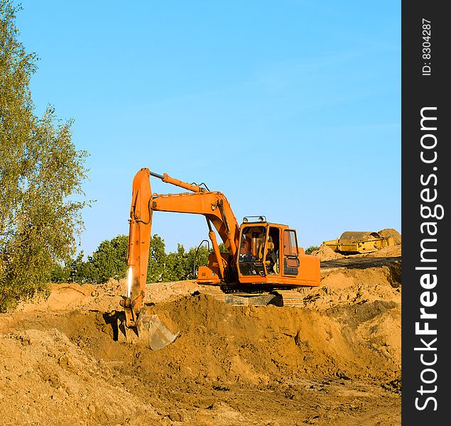 Excavator digging sand, on blue sky. Excavator digging sand, on blue sky