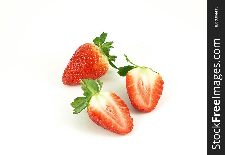 Strawberries halved on white studio isolated background.