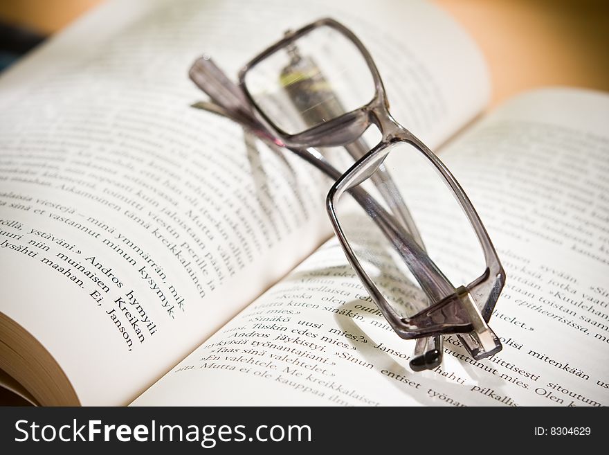 Closeup of opened book and glasses