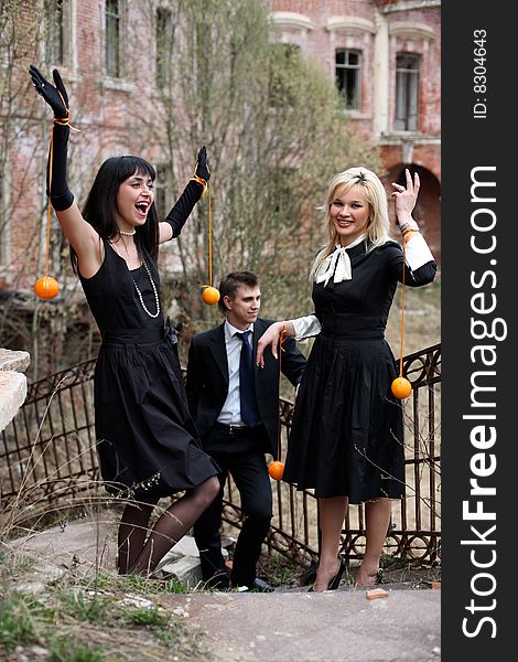 Two girl with oranges and man beside old house. Two girl with oranges and man beside old house