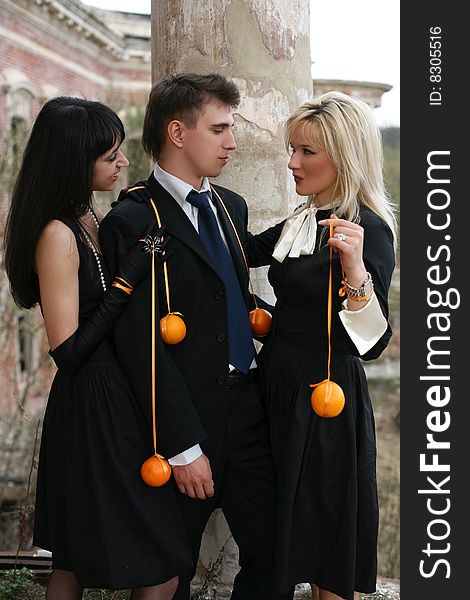 Two girl with oranges and man beside old house. Two girl with oranges and man beside old house