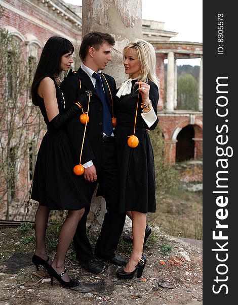 Two girl with oranges and man at old house. Two girl with oranges and man at old house