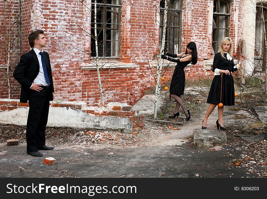 Two girl with oranges and man beside old house. Two girl with oranges and man beside old house