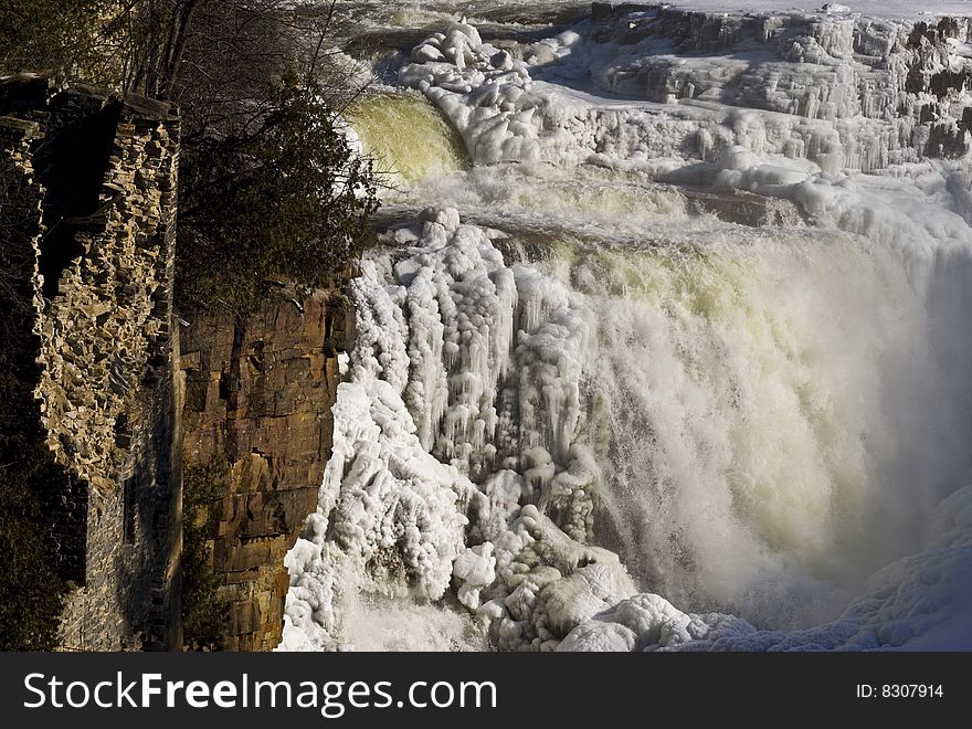 Waterfall in the winter in Ausable Chasm, upstate New York. Including the partially destroyed structure of an old building. Waterfall in the winter in Ausable Chasm, upstate New York. Including the partially destroyed structure of an old building