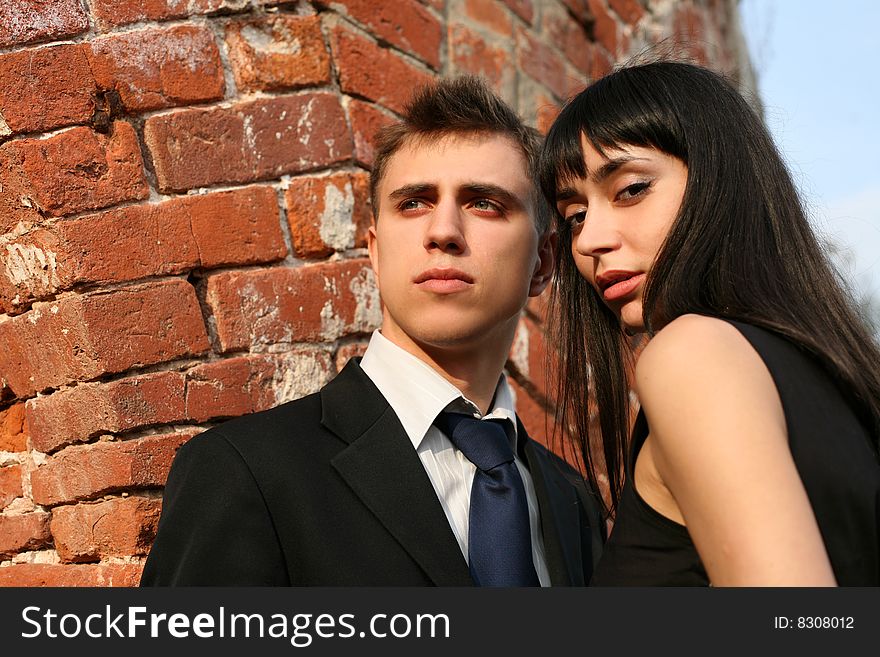 Young lovely couple beside wall