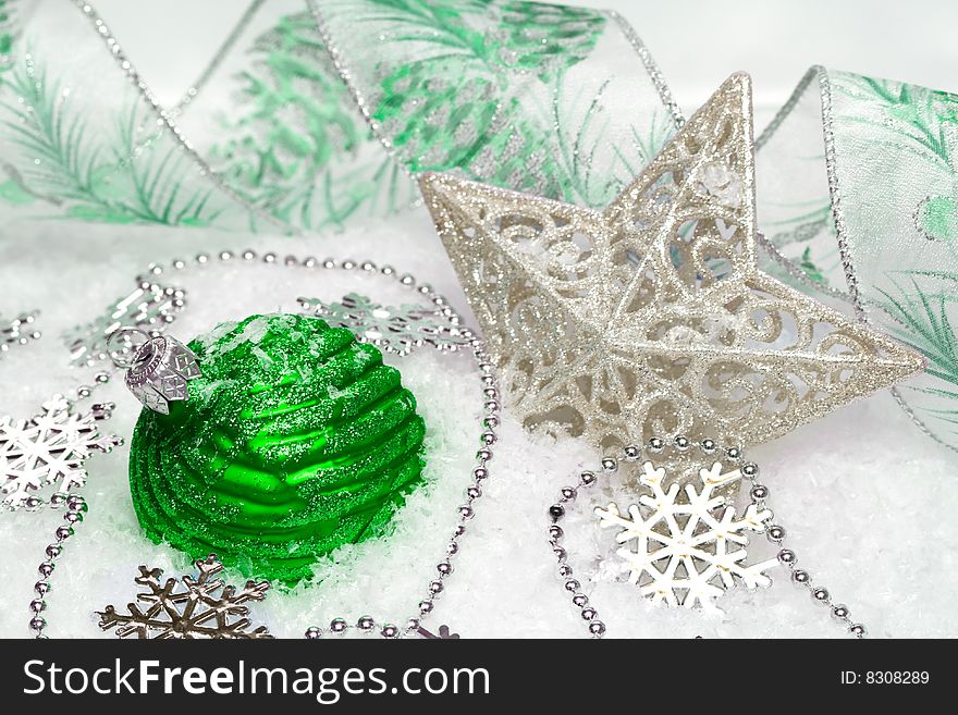 Green festive decoration and star on snow